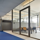 Aluminum door and door frame fully surrounded by glass