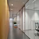 Corridor with on the right side iQ Structural glass system wall with seamless panel joins.