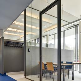 Aluminum door and door frame fully surrounded by glass