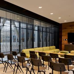 Within a meeting room with blinds inside the glass partition walls of QbiQ