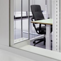 Double glass office wall with acoustic slots between the glas