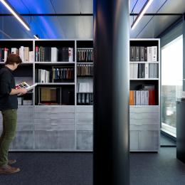 Glass partition with a bookcase in front at The Flow Houthavens Amsterdam